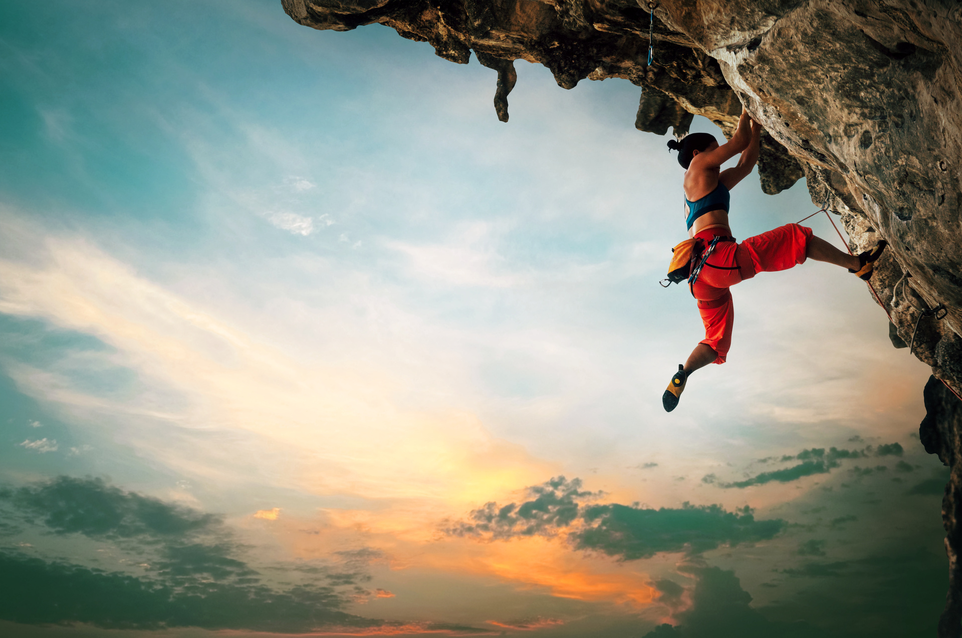 Freeclimber klettert unter einem Felsen entlang nach oben