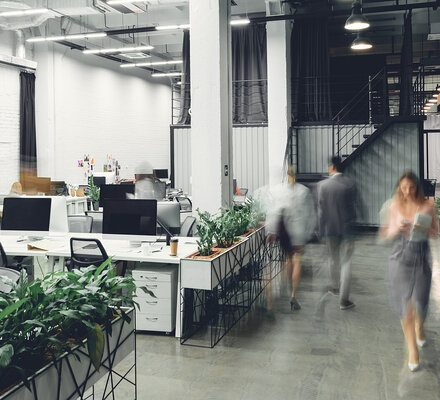 Team im modernen Büro begrüßt neue Mitarbeitende – Erleichterte Einstellung bei bestehender betrieblicher Altersvorsorge (bAV)