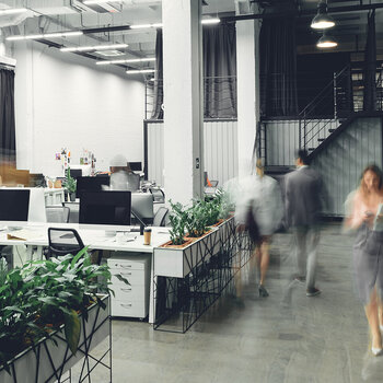 Team im modernen Büro begrüßt neue Mitarbeitende – Erleichterte Einstellung bei bestehender betrieblicher Altersvorsorge (bAV)